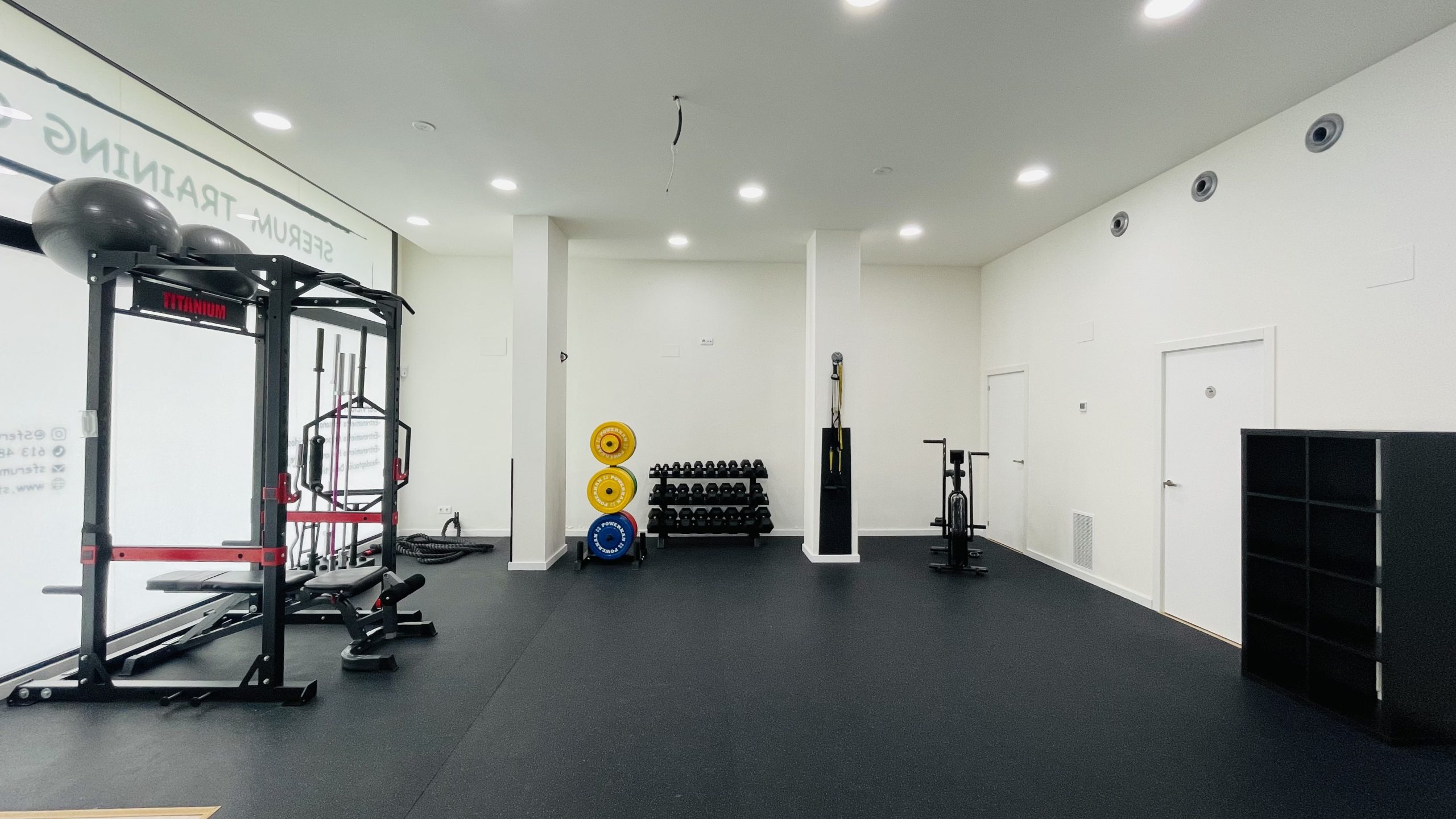centro de entrenamiento personal con material deportivo como pesas, mancuernas, discos de fuerza, trx, bici estatica, cuerda de fuerza, barra de fuerza